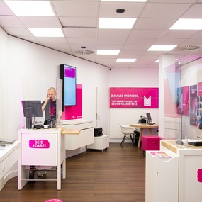 Moderner Telekom-Shop mit Beratungstresen, Smartphones und Werbetafeln für Mobilfunk.
