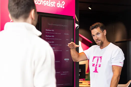 Telekom Mitarbeiter erklärt Mobilfunktarife am Touchscreen im Shop
