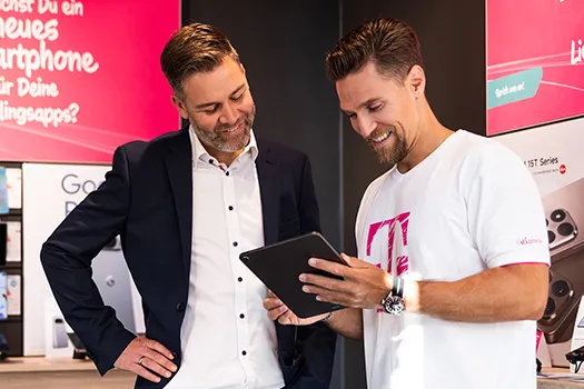 Telekom Mitarbeiter berät Kunden im Shop am Tablet, Smartphone Beratung